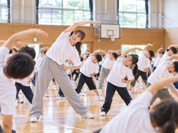 講師と一緒にストレッチをする子どもたち